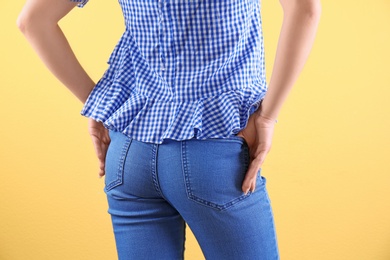 Photo of Woman in stylish blue jeans on color background