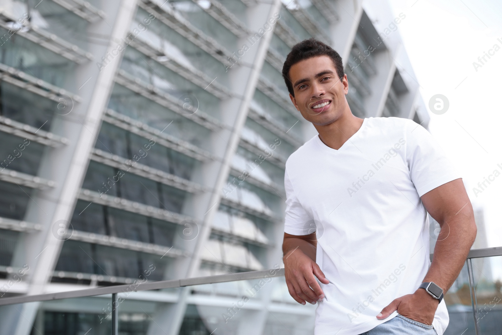 Photo of Handsome young African-American man on city street. Space for text