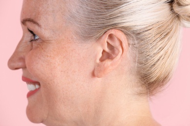 Mature woman on color background, closeup. Hearing problem