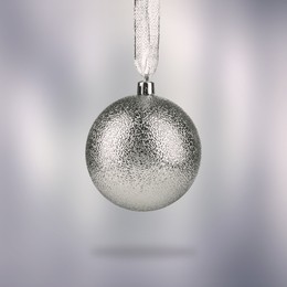 Image of Beautiful silver Christmas ball hanging on light grey background