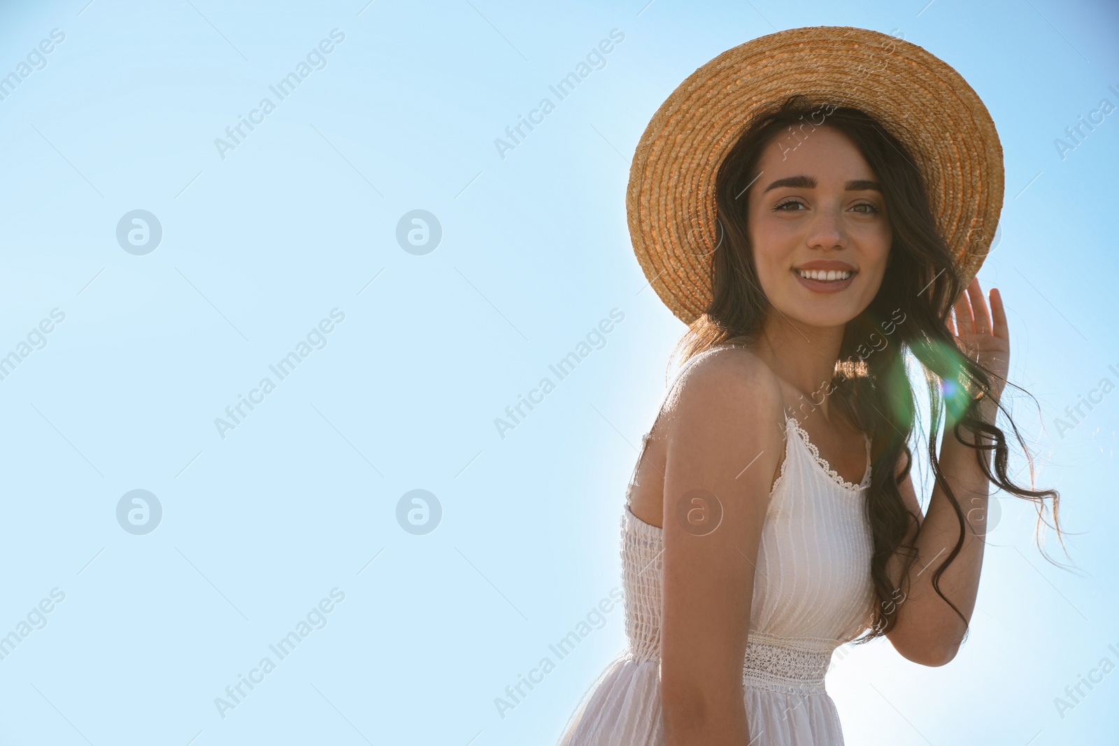 Photo of Happy young woman with beach hat against blue sky on sunny day