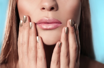 Photo of Beautiful woman with stylish nail polish on color background, closeup