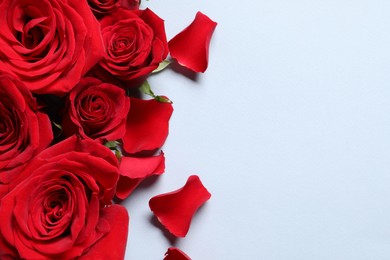 Photo of Beautiful red roses and petals on grey background, flat lay. Space for text