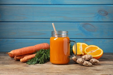 Photo of Freshly made carrot smoothie in mason jar and ingredients on wooden table