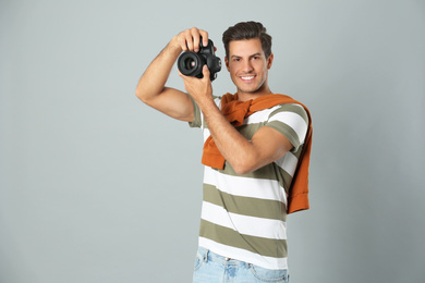 Photo of Professional photographer working on light grey background in studio