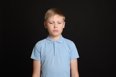 Upset boy on black background. Children's bullying
