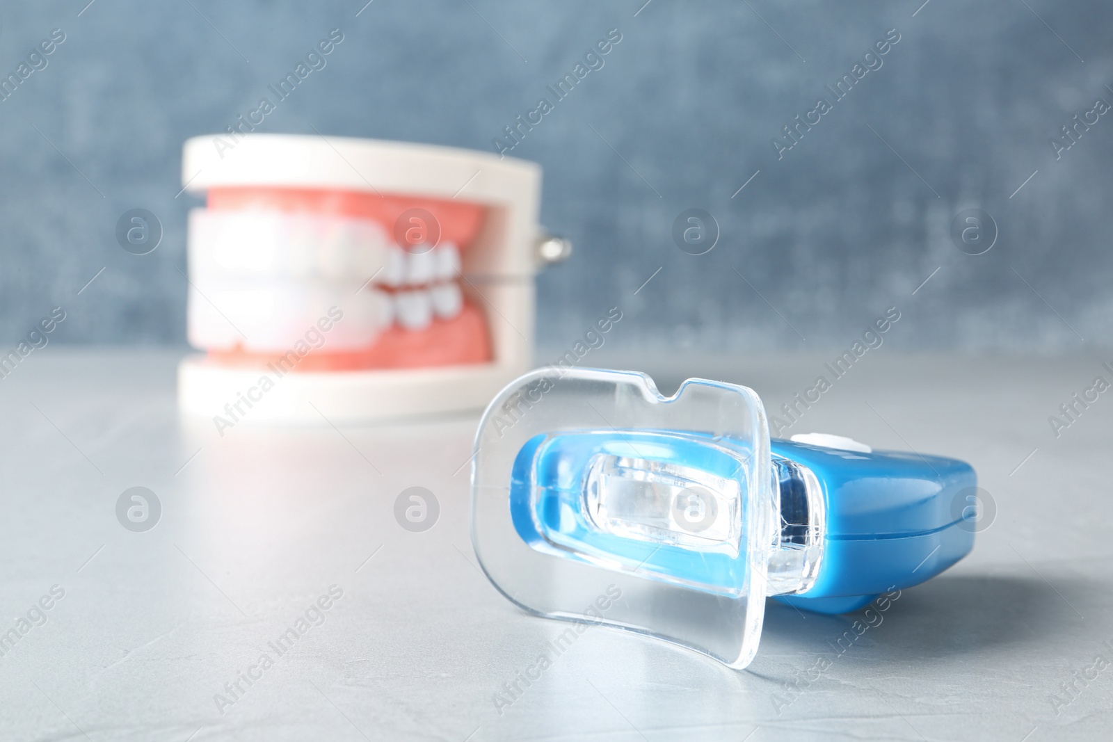 Photo of Teeth whitener on table against blurred background. Space for text