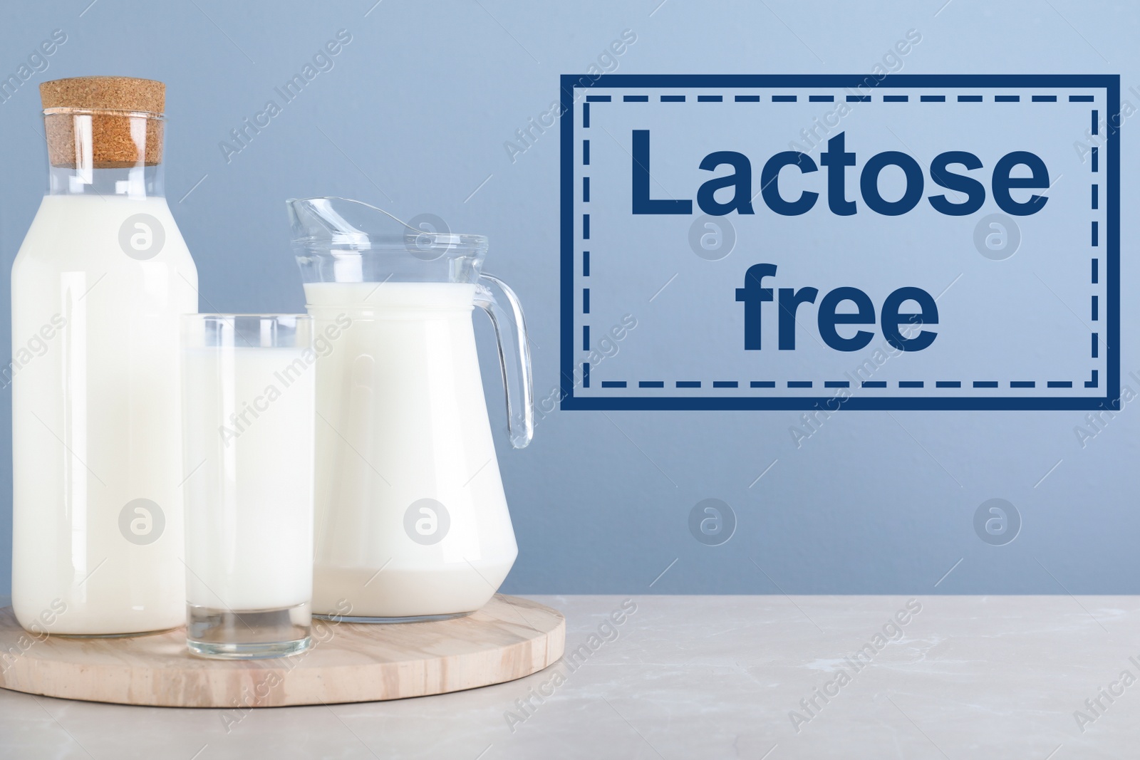 Image of Fresh lactose free milk on white table against light blue background