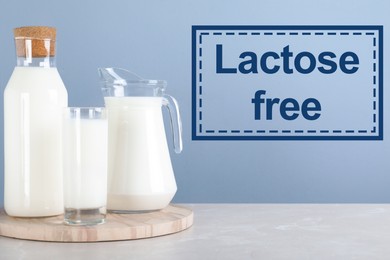 Image of Fresh lactose free milk on white table against light blue background