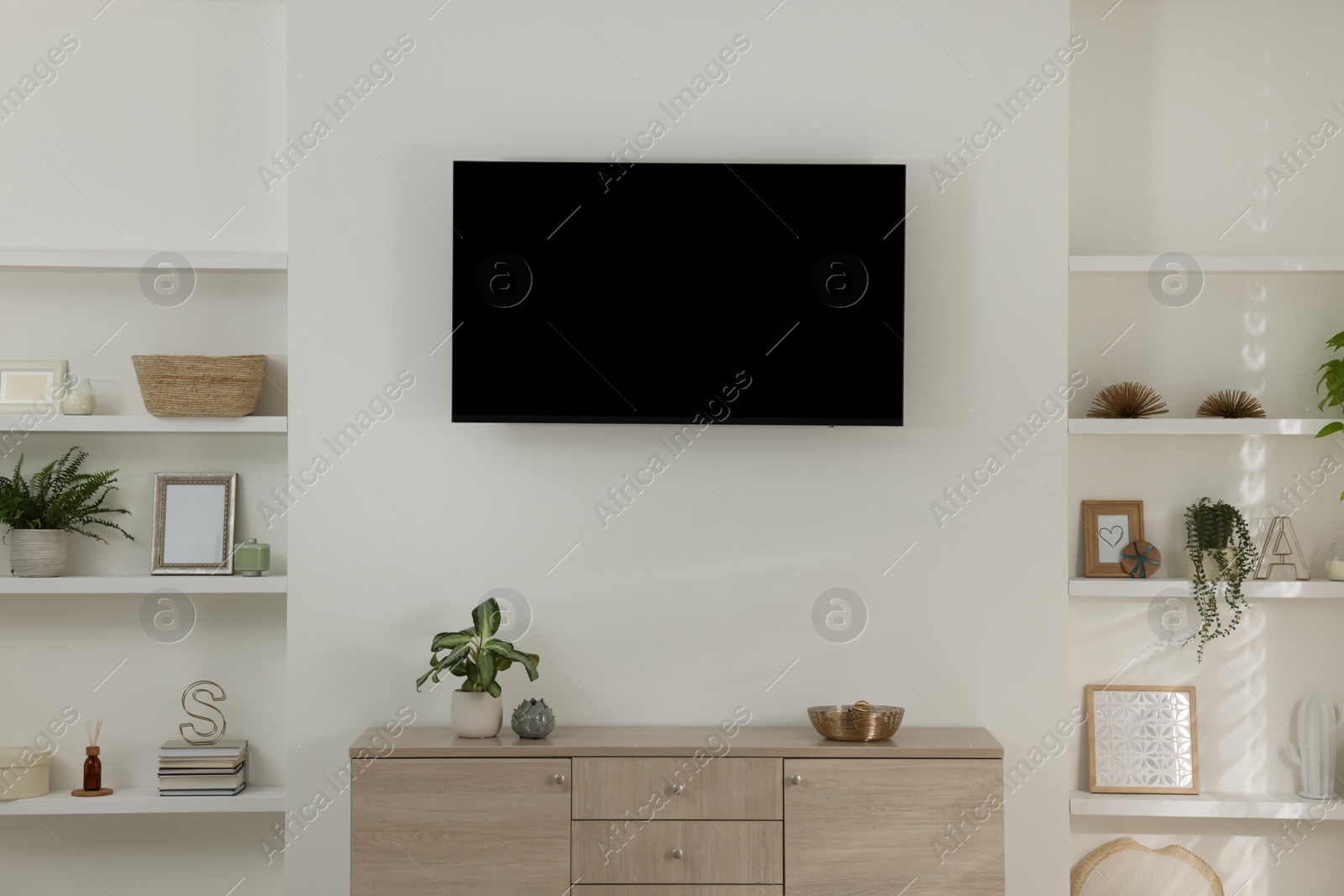 Photo of Stylish TV set mounted on wall in room