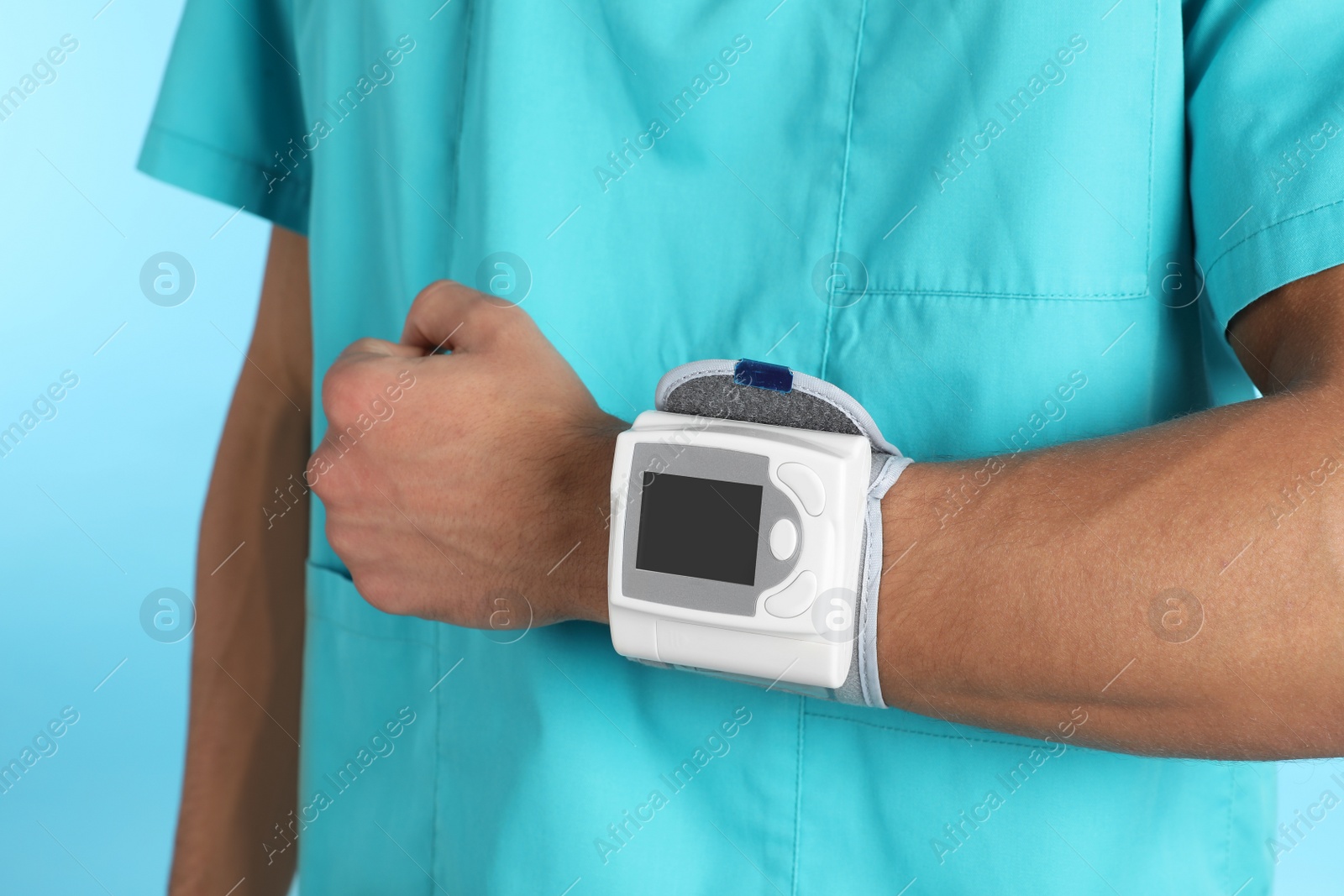 Photo of Male doctor using blood pressure monitor on color background, closeup. Medical object