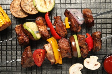 Delicious shish kebabs with vegetables on grey table, flat lay