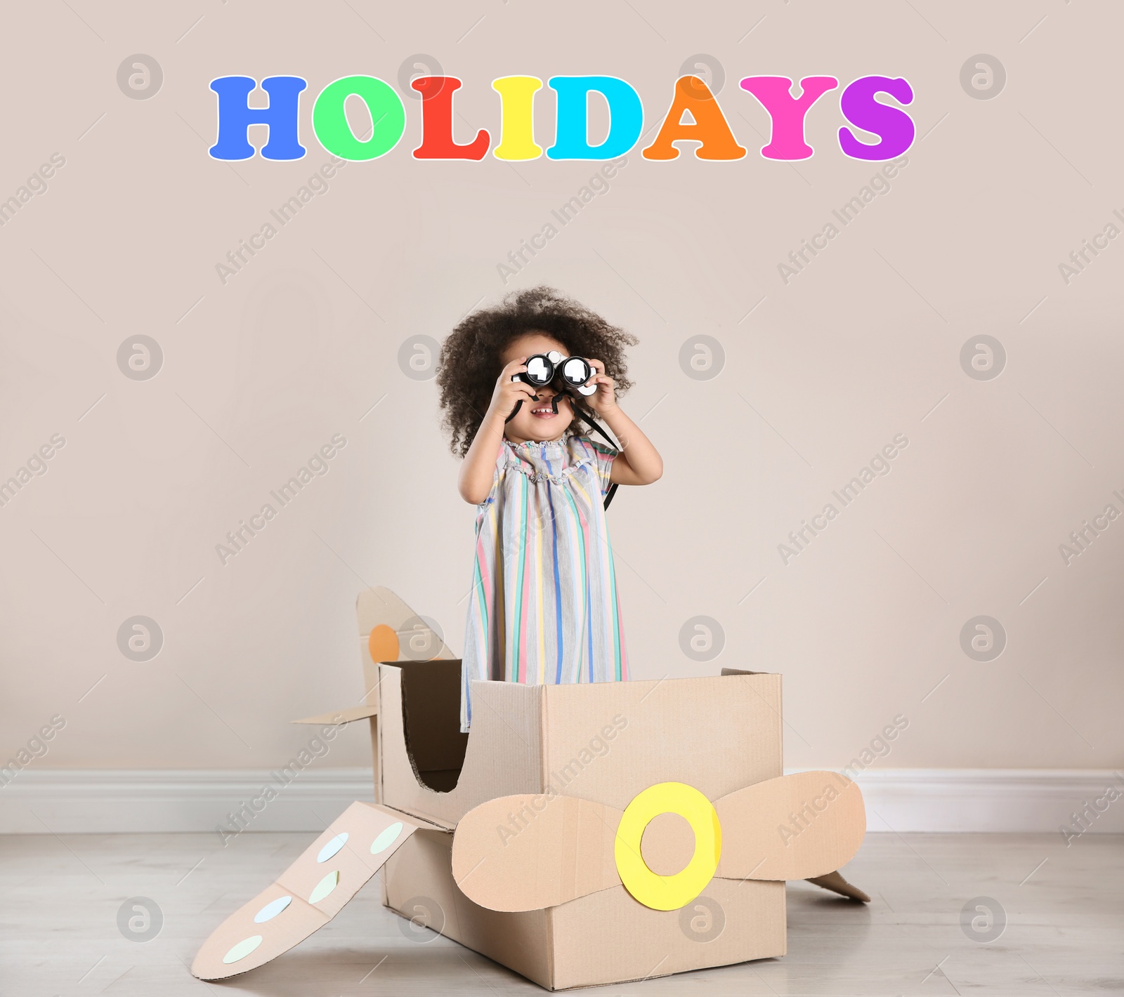 Image of School holidays. Cute little child playing with cardboard plane near beige wall