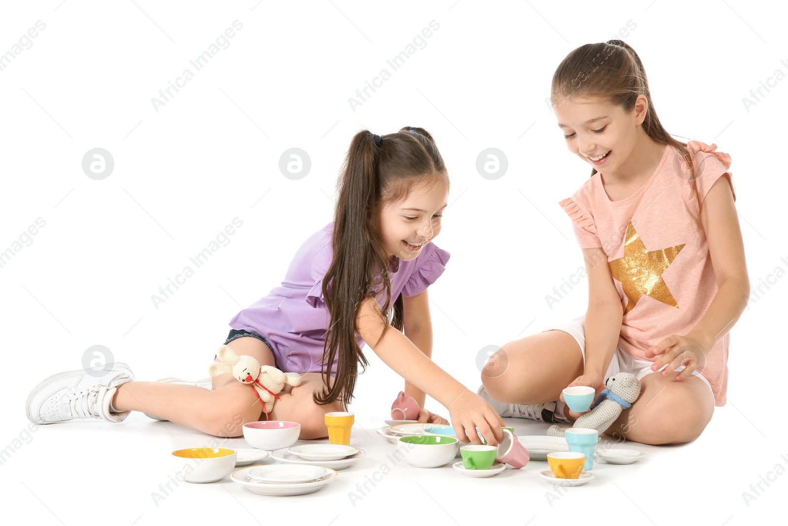 Photo of Little children playing tea party with toys on white background. Indoor entertainment