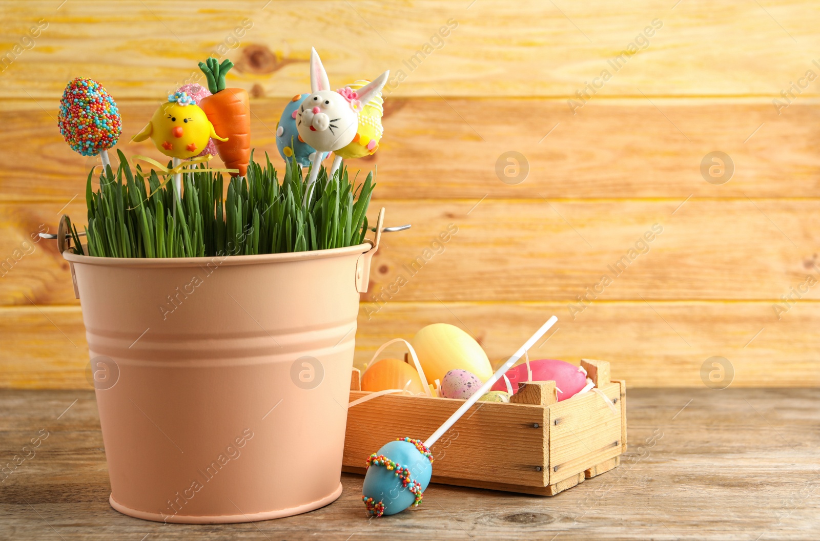 Photo of Delicious sweet cake pops on wooden table, space for text. Easter holiday