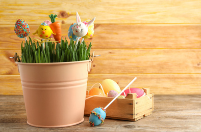 Delicious sweet cake pops on wooden table, space for text. Easter holiday