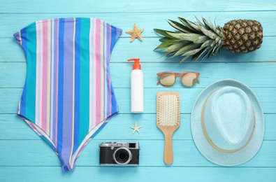Photo of Flat lay composition with beach accessories on light blue wooden background