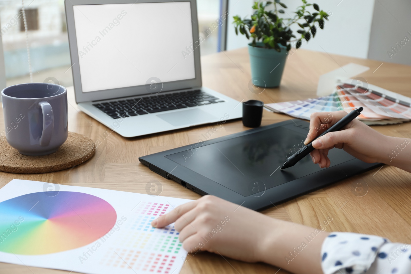 Photo of Professional designer with graphic tablet at wooden table, closeup