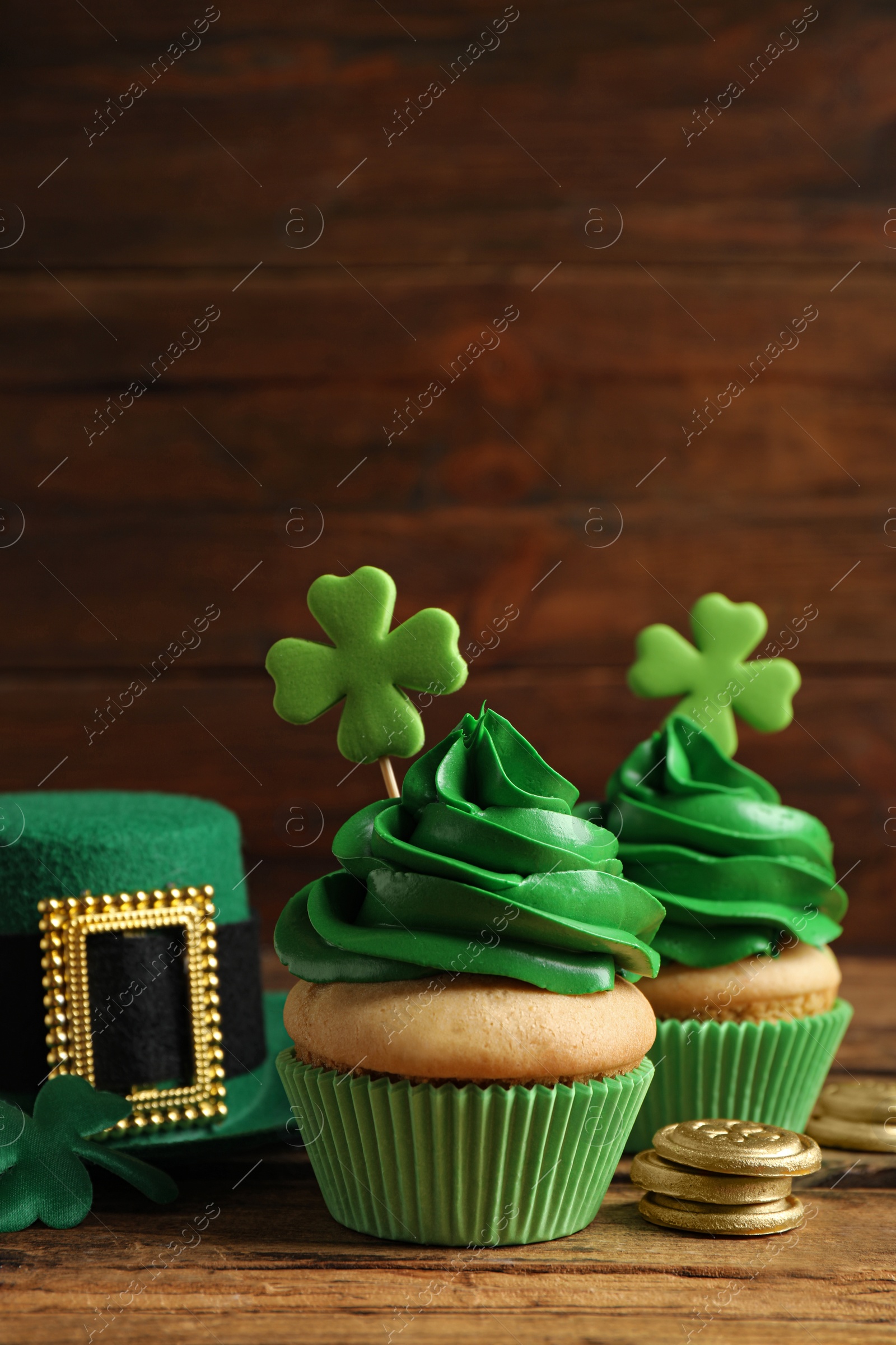 Photo of Composition with delicious decorated cupcakes on wooden table. St. Patrick's Day celebration