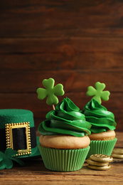 Composition with delicious decorated cupcakes on wooden table. St. Patrick's Day celebration