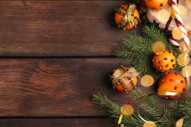 Photo of Flat lay composition with pomander balls made of fresh tangerines and cloves on wooden table, space for text