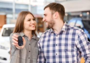 Photo of Young couple holding car key in salon