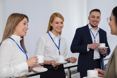 Photo of Group of people chatting during coffee break indoors