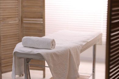 Rolled towel on massage table in spa center