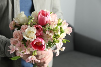 Man holding bouquet of beautiful flowers indoors, closeup