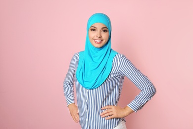 Photo of Portrait of young Muslim woman in hijab against color background