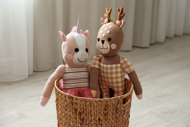Photo of Funny toy unicorn and deer in basket on floor. Decor for children's room interior