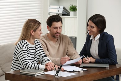 Couple consulting with professional notary in office