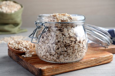 Photo of Glass jar with oatmeal on white wooden table