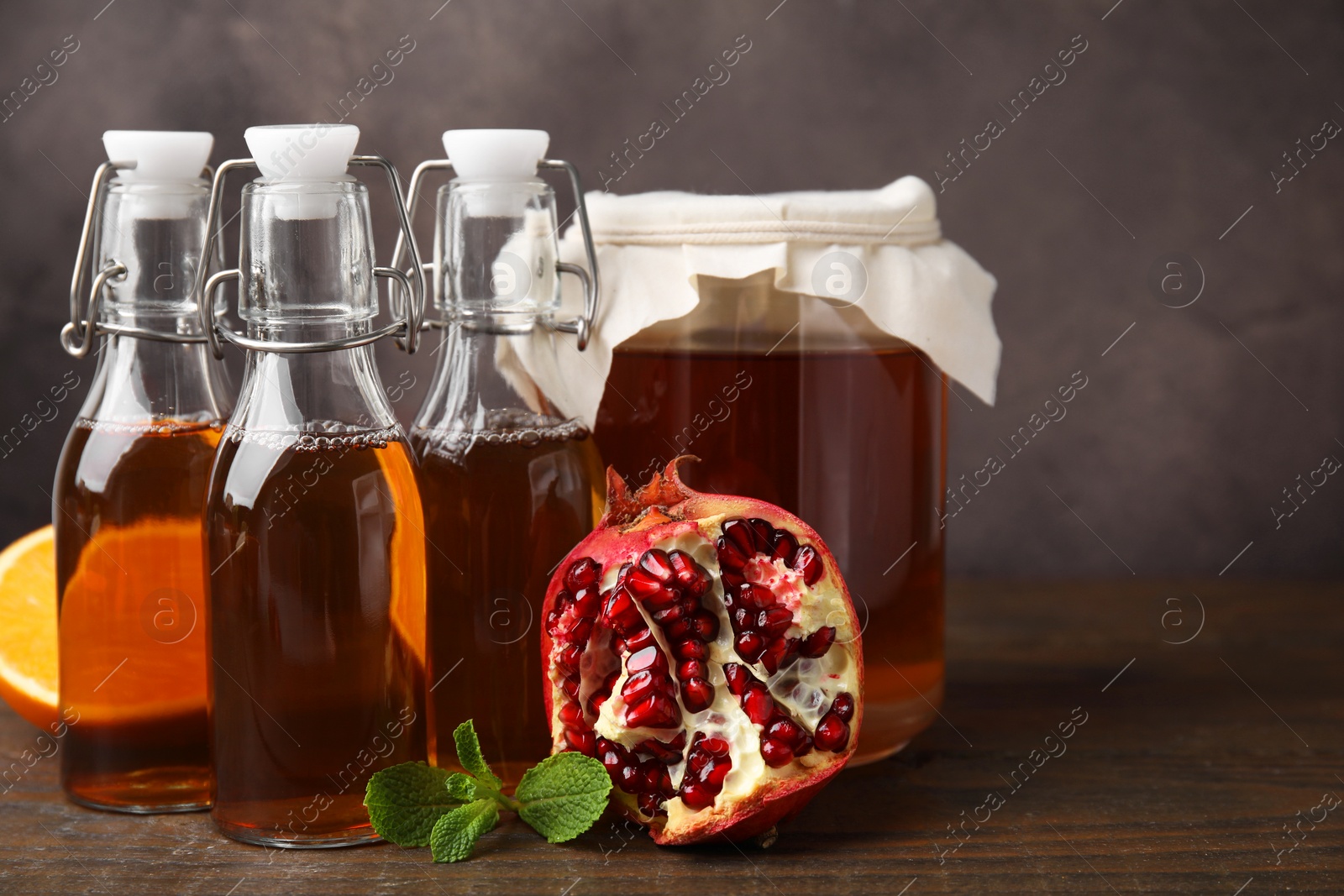 Photo of Tasty kombucha, mint and fresh fruits on wooden table