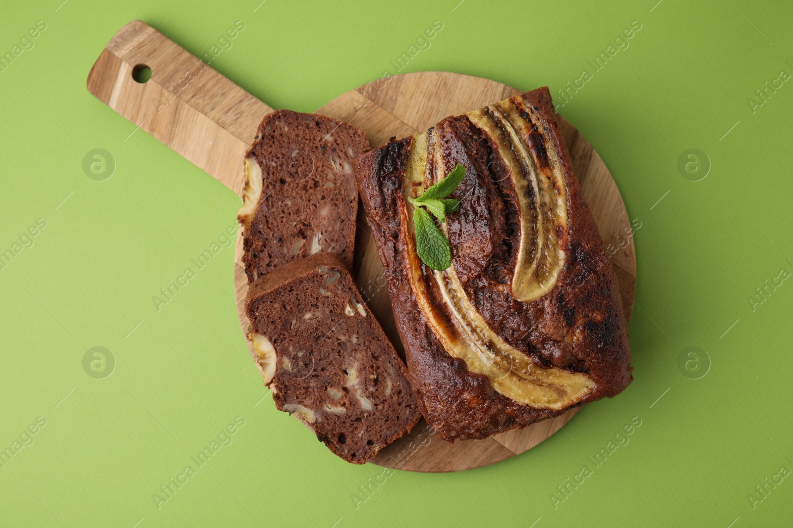 Photo of Delicious banana bread with mint on green background, top view