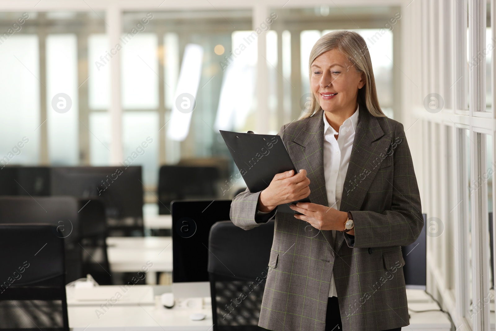 Photo of Smiling woman with clipboard in office, space for text. Lawyer, businesswoman, accountant or manager