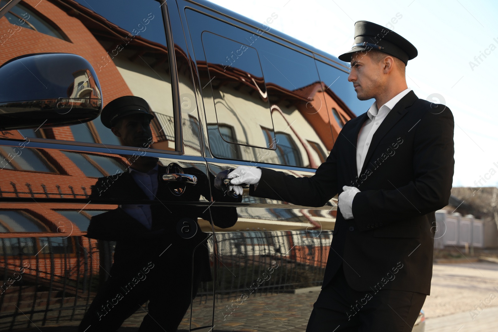 Photo of Driver opening door of luxury car. Chauffeur service