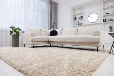 Photo of Fluffy carpet and stylish furniture on floor indoors