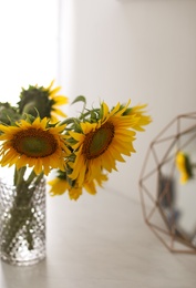 Vase with beautiful yellow sunflowers on table
