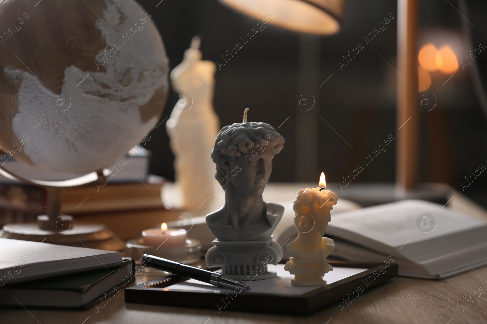 Photo of Beautiful David bust candles on table indoors