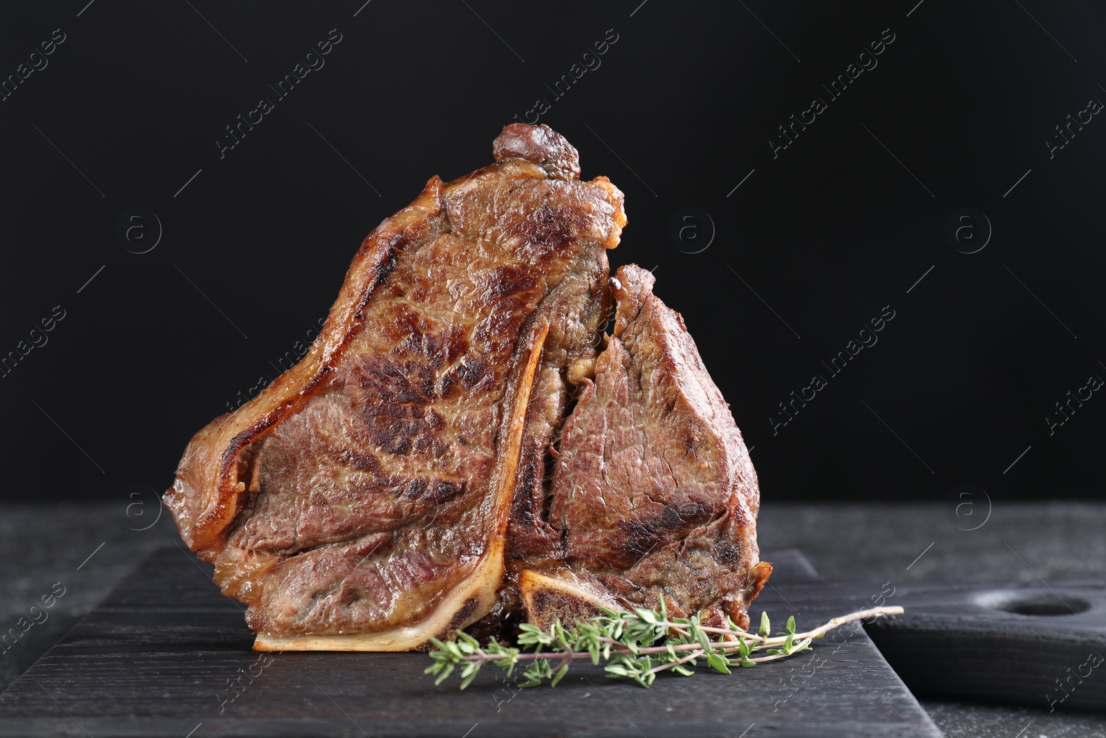 Photo of Delicious fried beef meat and thyme on table