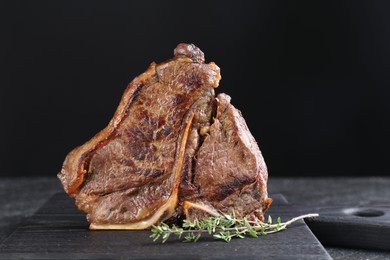 Photo of Delicious fried beef meat and thyme on table