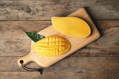 Flat lay composition with mango on wooden background