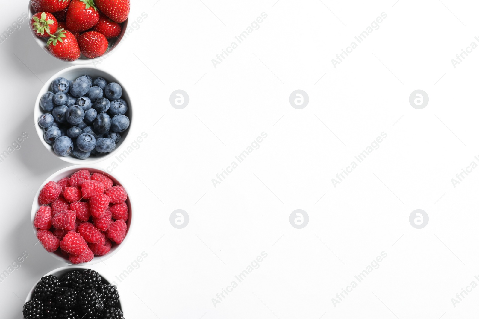 Photo of Bowls with raspberries and different berries on white background