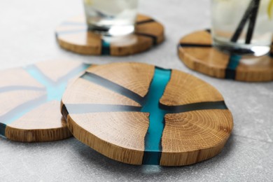 Stylish wooden cup coasters on light grey table, closeup