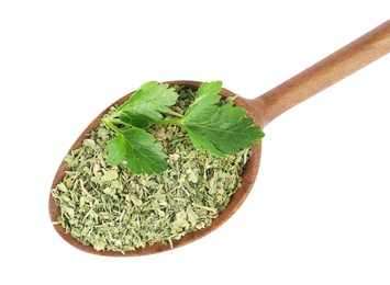 Photo of Wooden spoon with dried parsley and fresh twig on white background, top view