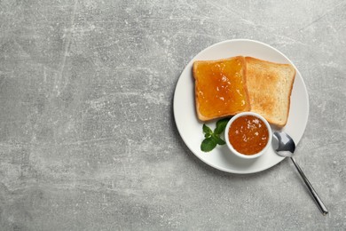 Photo of Delicious toasts served with jam and mint on light grey table, top view. Space for text