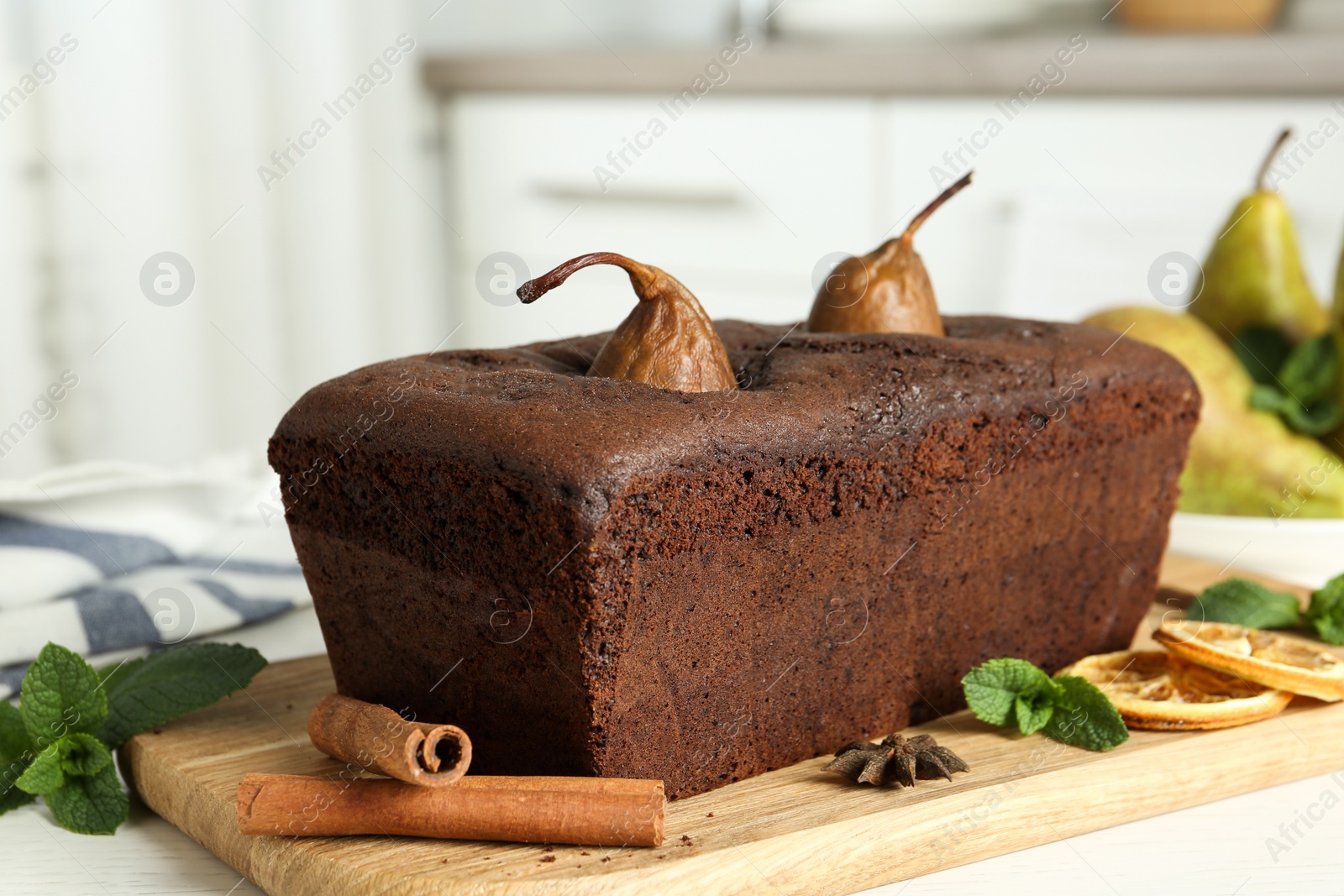 Photo of Tasty pear bread with mint, spices and dried orange slices on table. Homemade cake