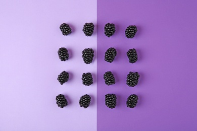 Photo of Tasty ripe blackberries on purple background, flat lay