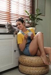 Young woman with cute cat at home. Pet and owner